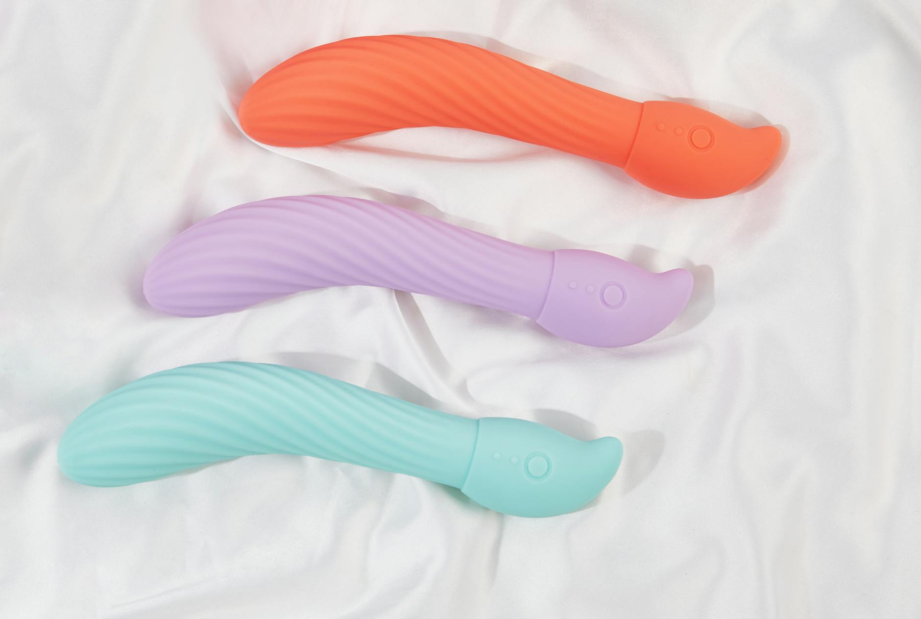 Three colorful lemon vibrators arranged on white fabric, highlighting their smooth texture and design