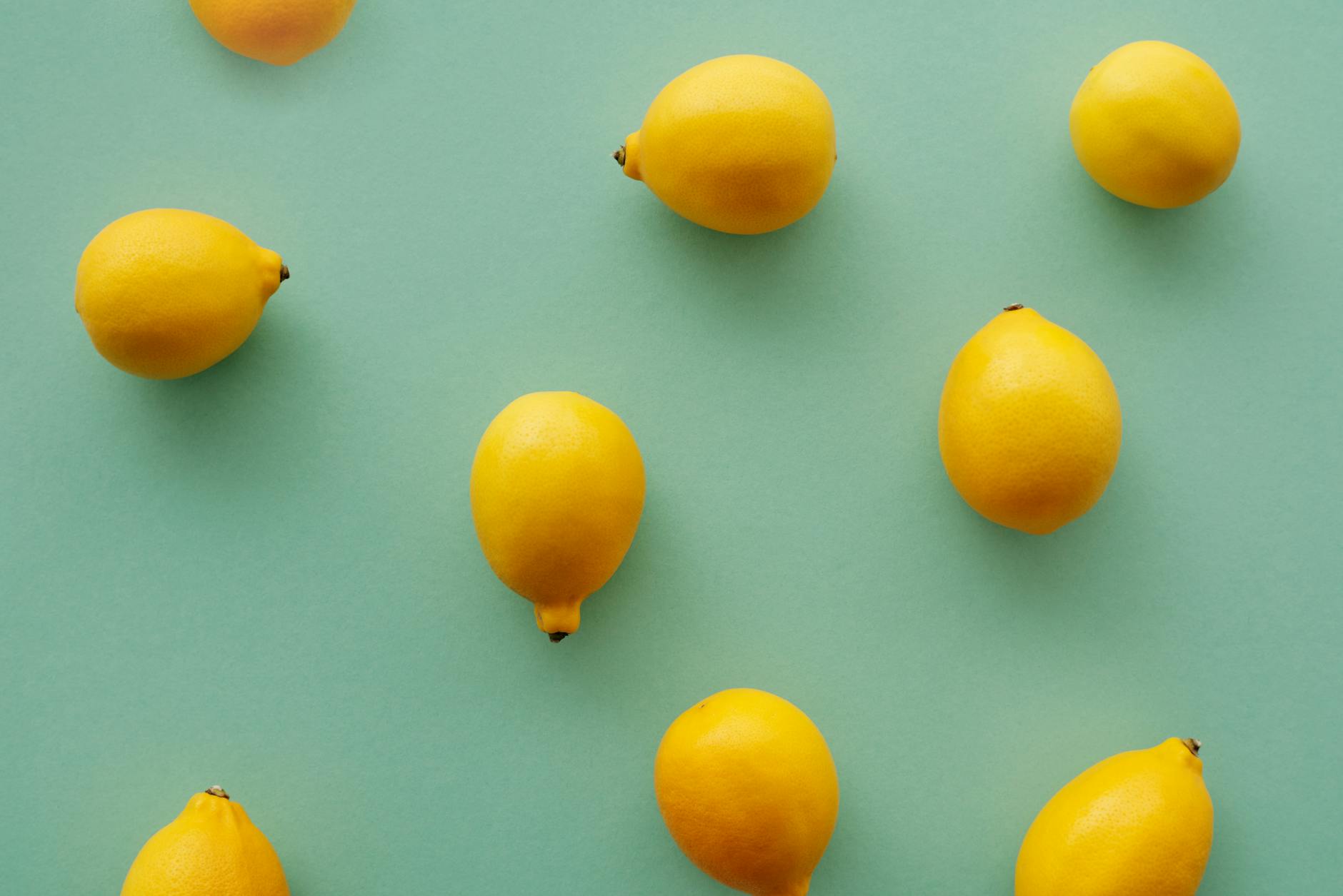 Fresh bright lemons on a pastel green background, symbolizing the refreshing reset that comes with anxiety-free pleasure