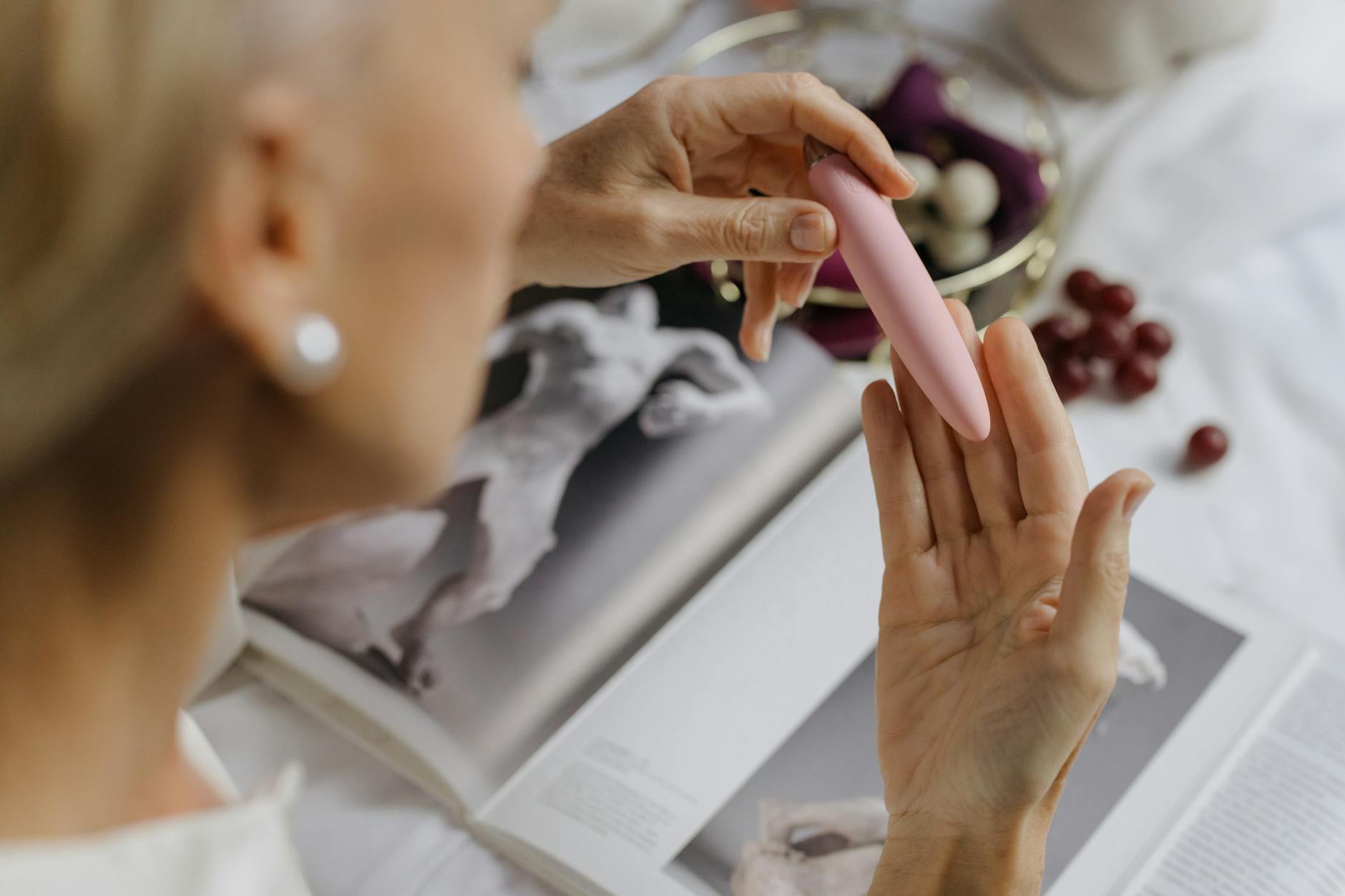 Woman holding blue and pink silicone vibrators thoughtfully, representing the return to intimate pleasure after time away