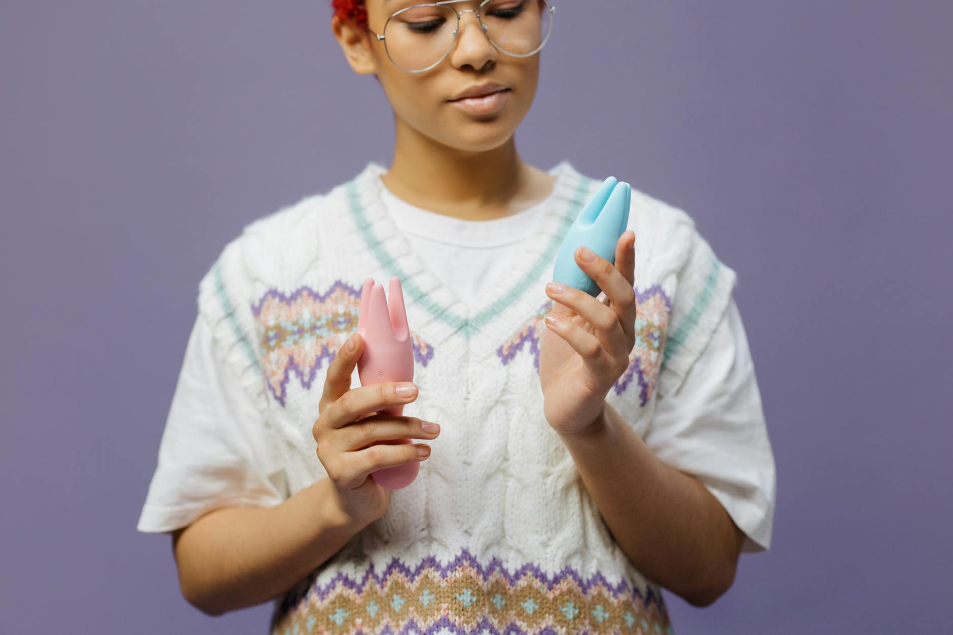 Woman holding vibrant blue and pink silicone vibrators, representing renewed pleasure in long-term relationships