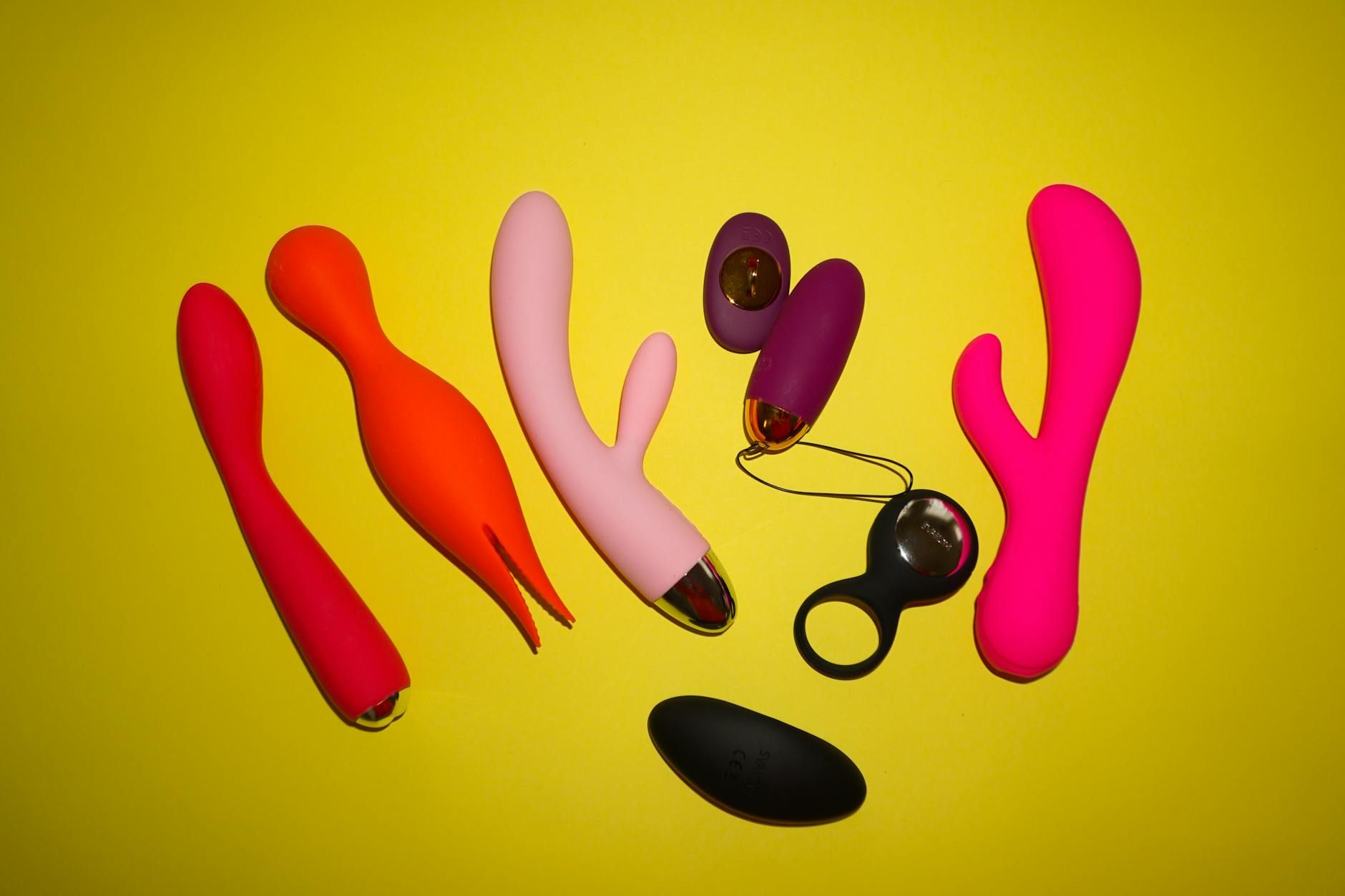 Hand holding a blue silicone vibrator against a purple background, symbolizing self-directed pleasure and body autonomy